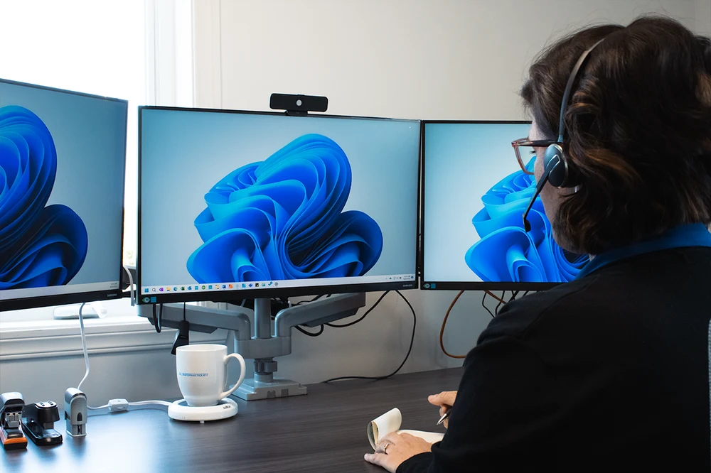 Une professionnelle échange à distance depuis son poste de travail.